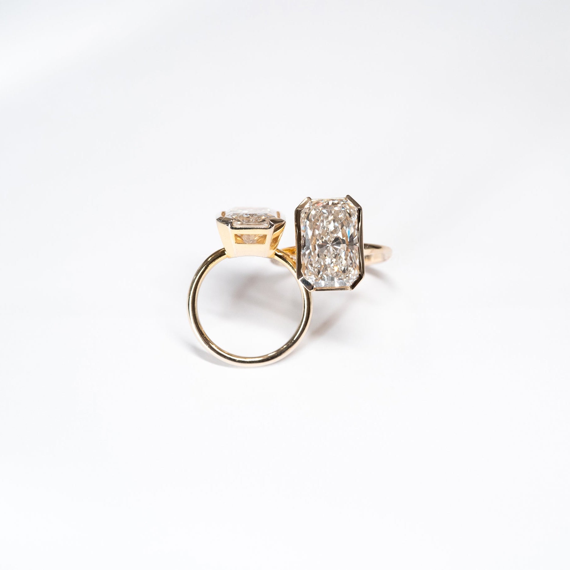 Two 8 carat radiant cut lab dimaond rings set in 14k yellow gold bezel settings.