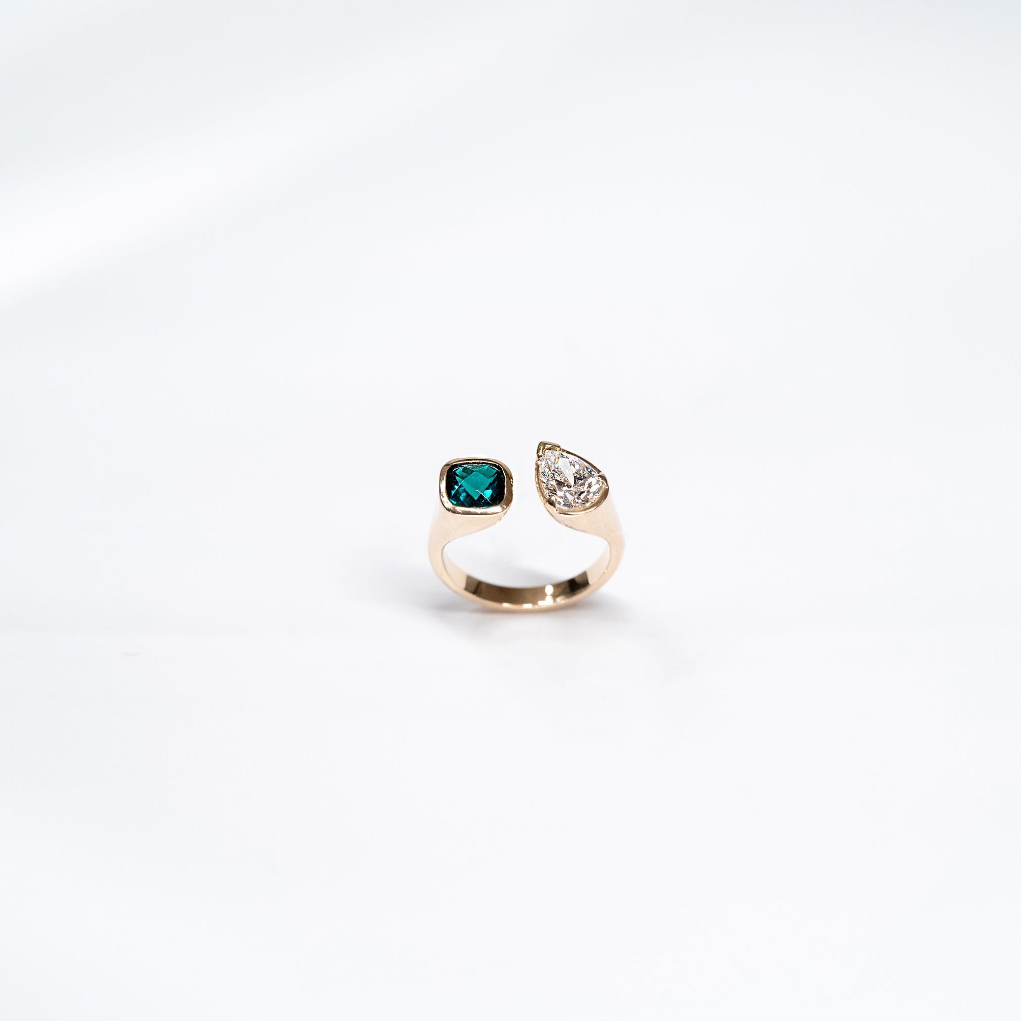 Toi Et Moi Gold ring with emerald radiant stone and pear shaped diamond.