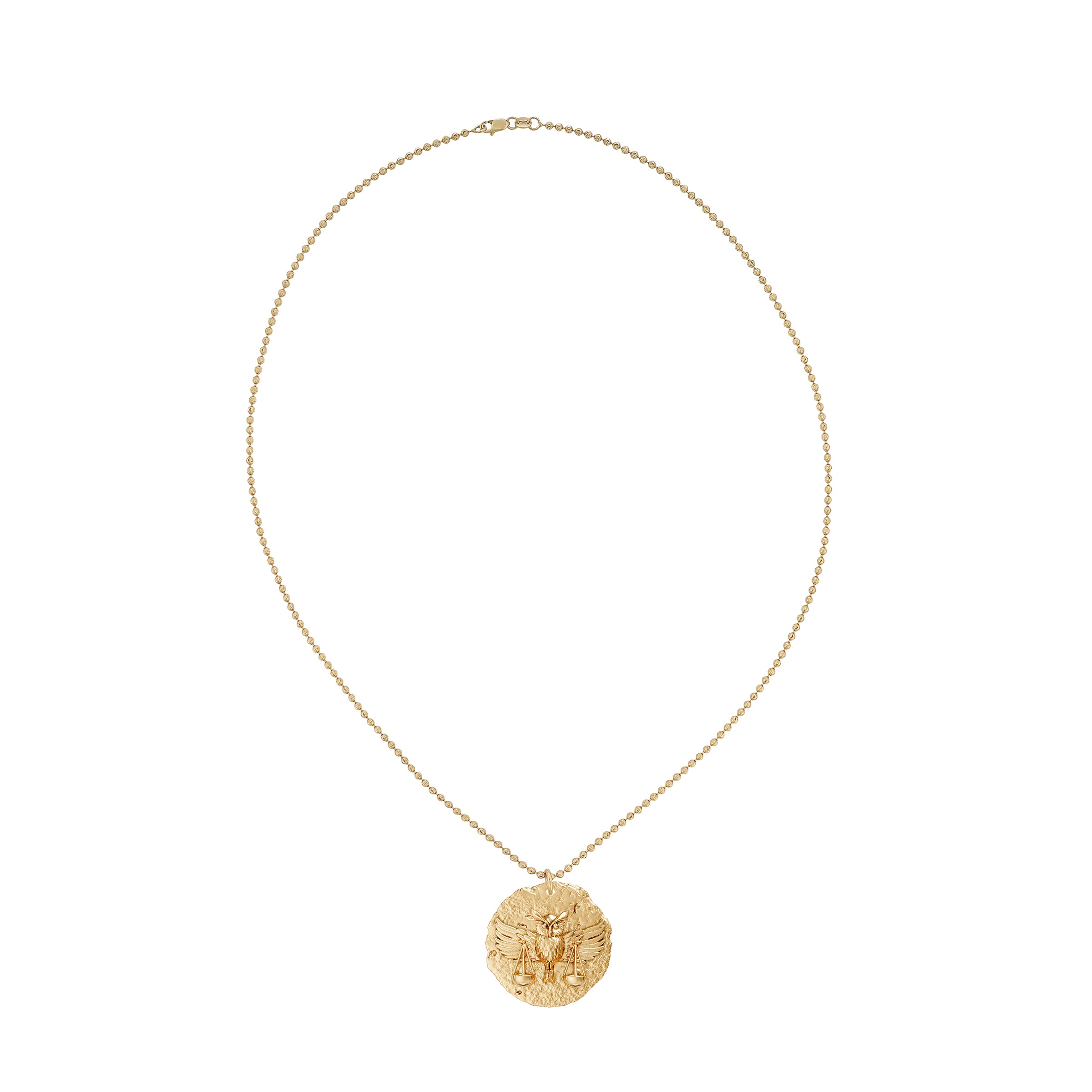 Gold necklace with a round zodiac libra pendant on small ball chain on a white background