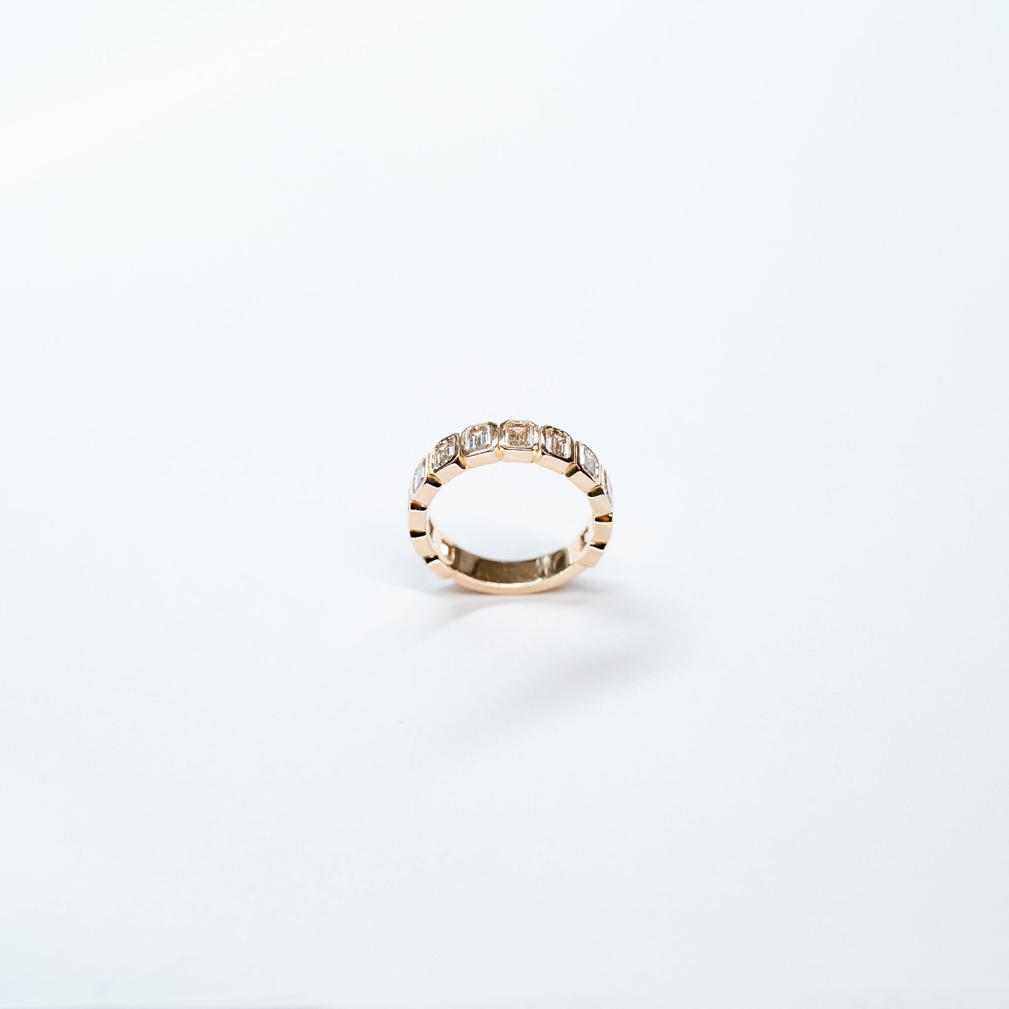 Side angle of emerald Cut Lab Diamond eternity band ste in 14k yelllow gold. 