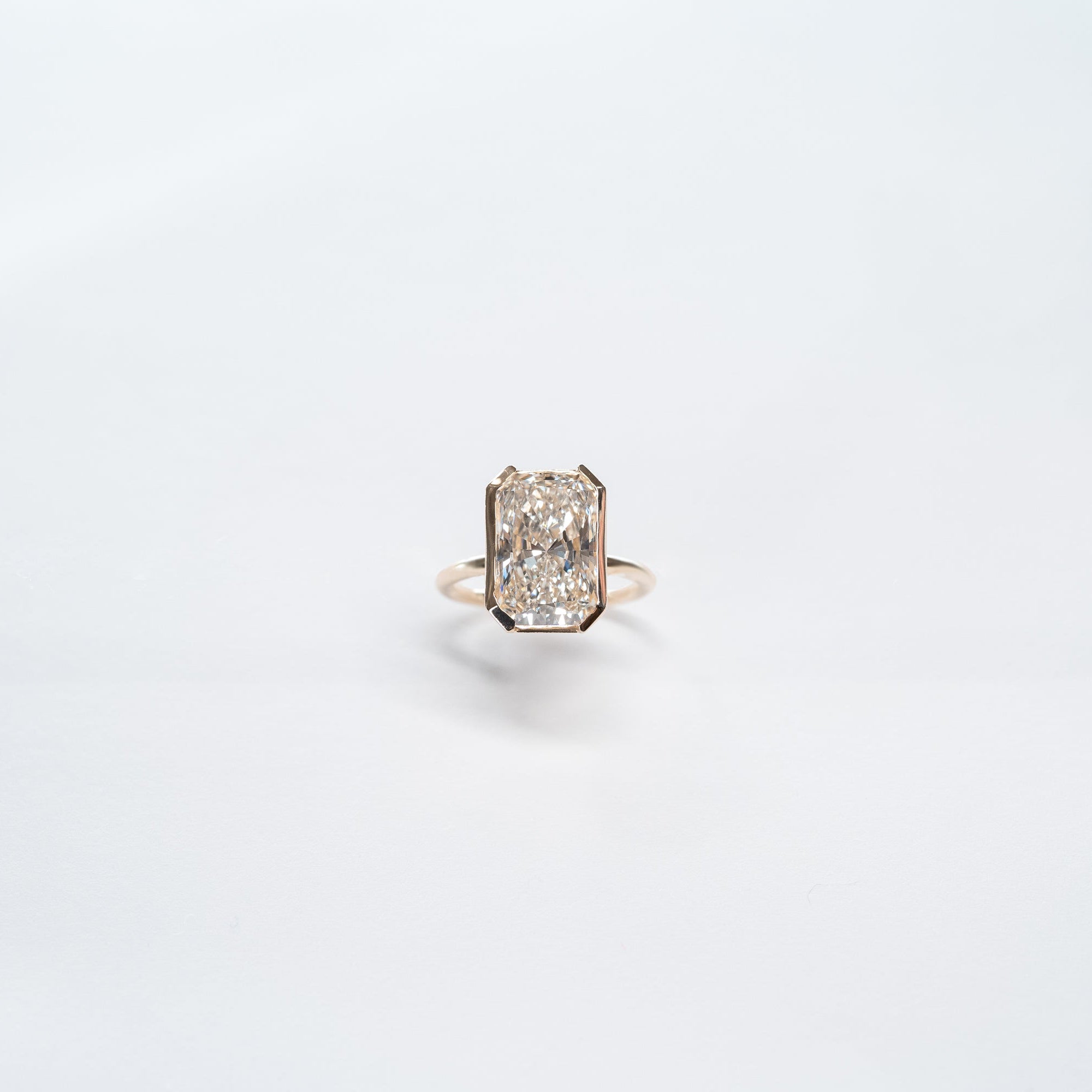 8 carat radiant cut lab dimaond set in 14k yellow gold bezel set ring.
