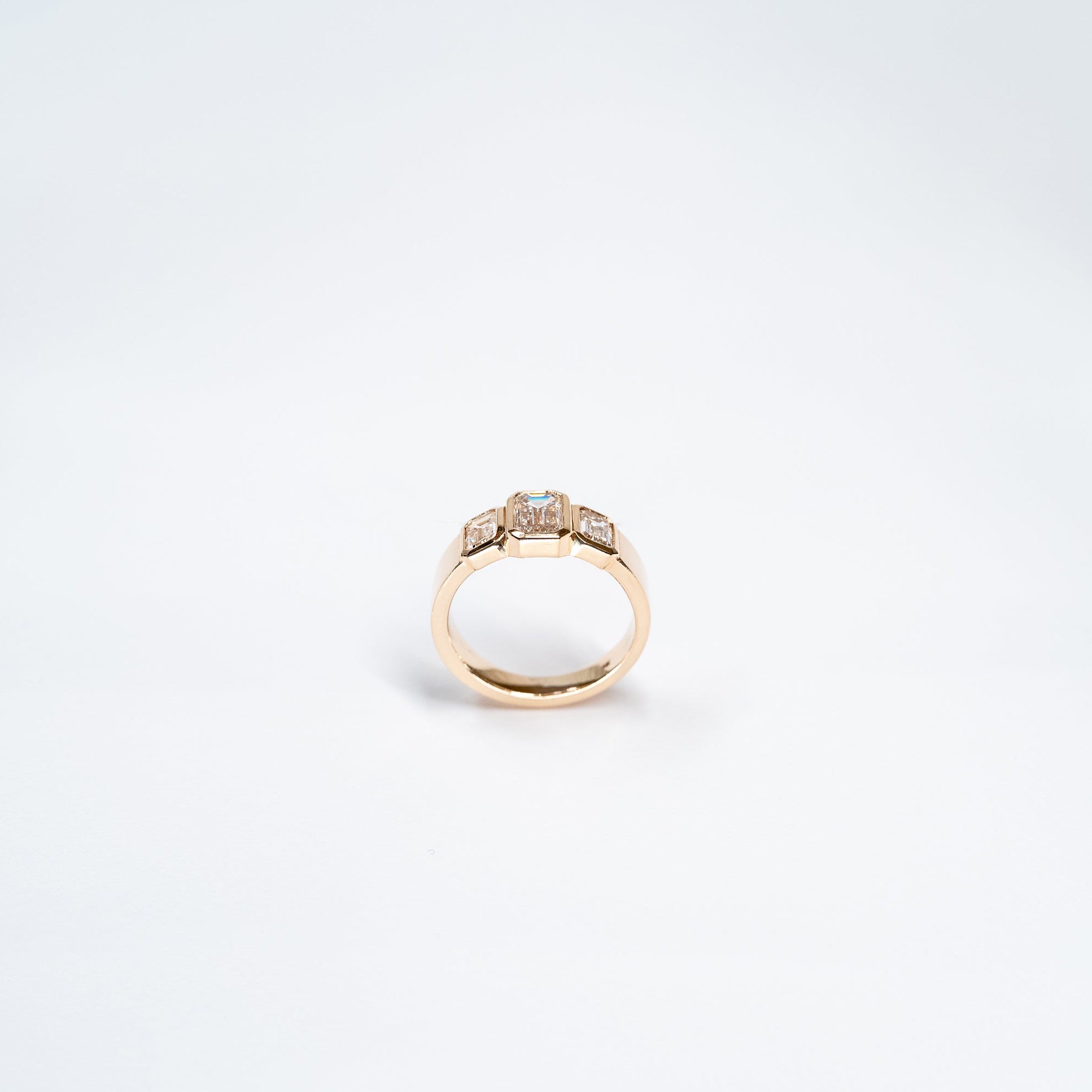 Side Angle of Three Lab Diamond Emerald Cut Ring set in 14k yellow gold.  Center Emerald Cut diamond is larger than two stones on the sides. 