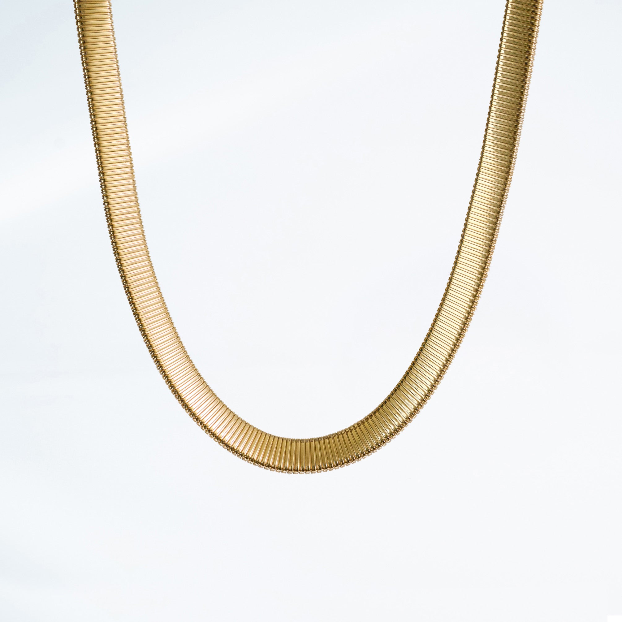 14k yellow gold tubogas necklace on a light gray background.